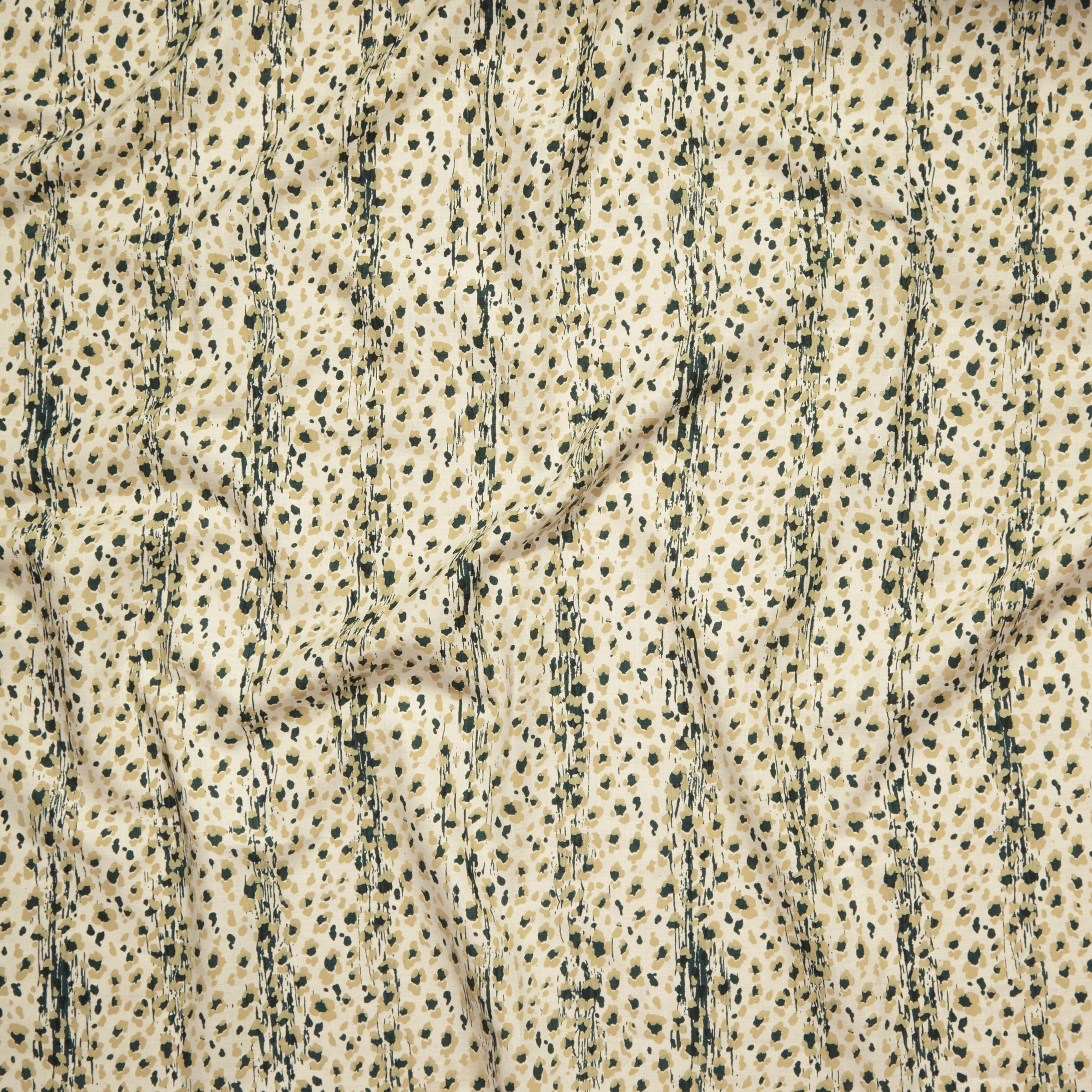 Close up of gently draped printed linen with small scale painterly animal print in dark green and tan on a beige background