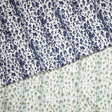 Layered fabric cuttings with a painterly animal print in navy blue and light blue and green on white. 