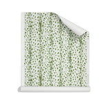 Roll of wallpaper with small scale painterly animal print in light blue and green on white. 
