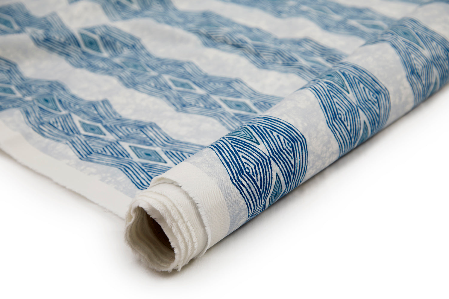 Partially unrolled fabric in an intricate diamond stripe print in blue and navy on a cream field.