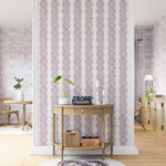 A maximalist living space with an accent wall papered in an intricate diamond stripe print in purple and cream.