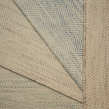 Stack of four broadloom carpet samples with herringbone pattern in soft pastel colors. 