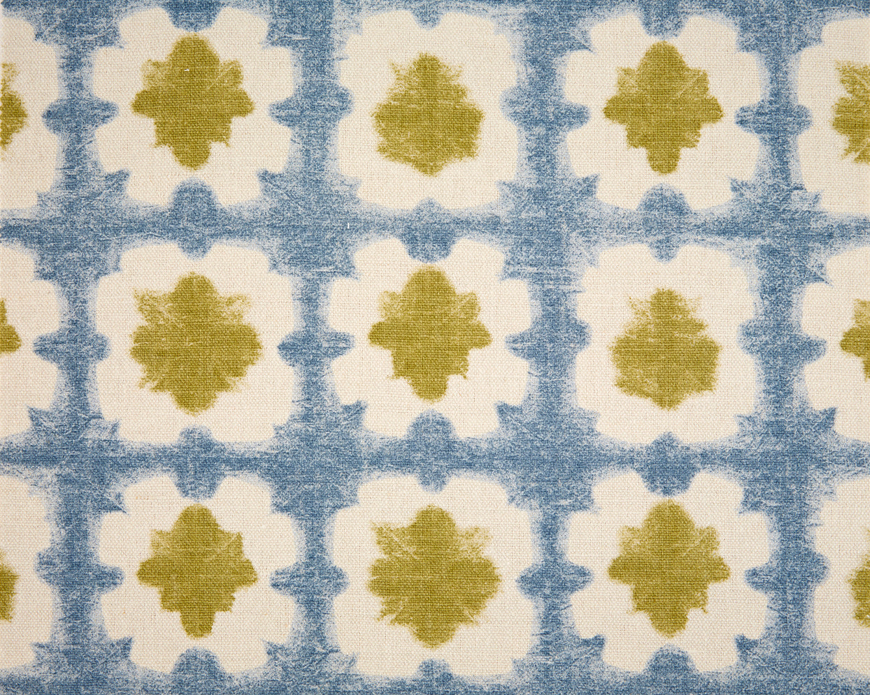 Detail of fabric in a dyed grid print in olive and blue on a cream field.