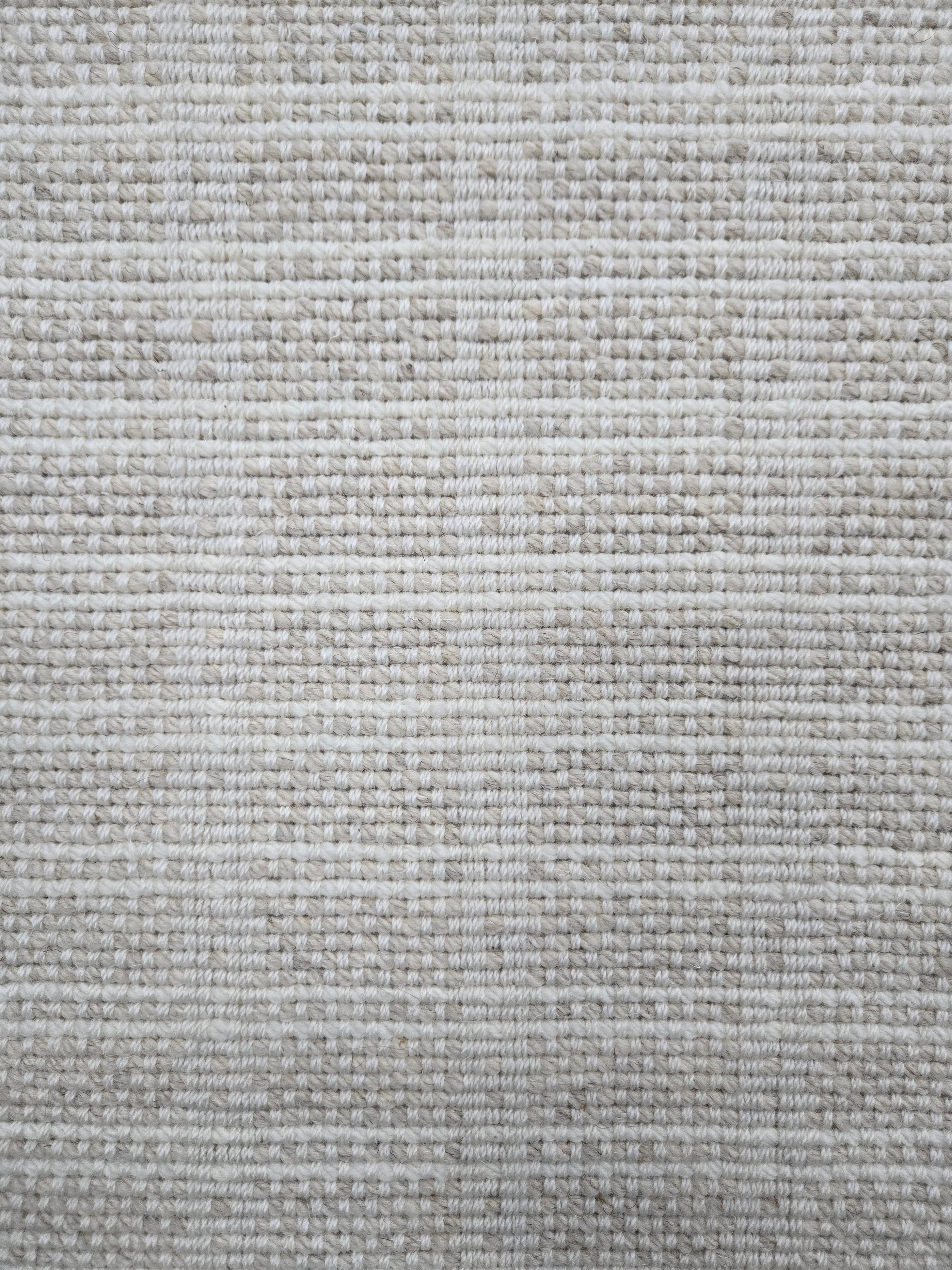 Broadloom carpet in slim plaid pattern in cream and beige.