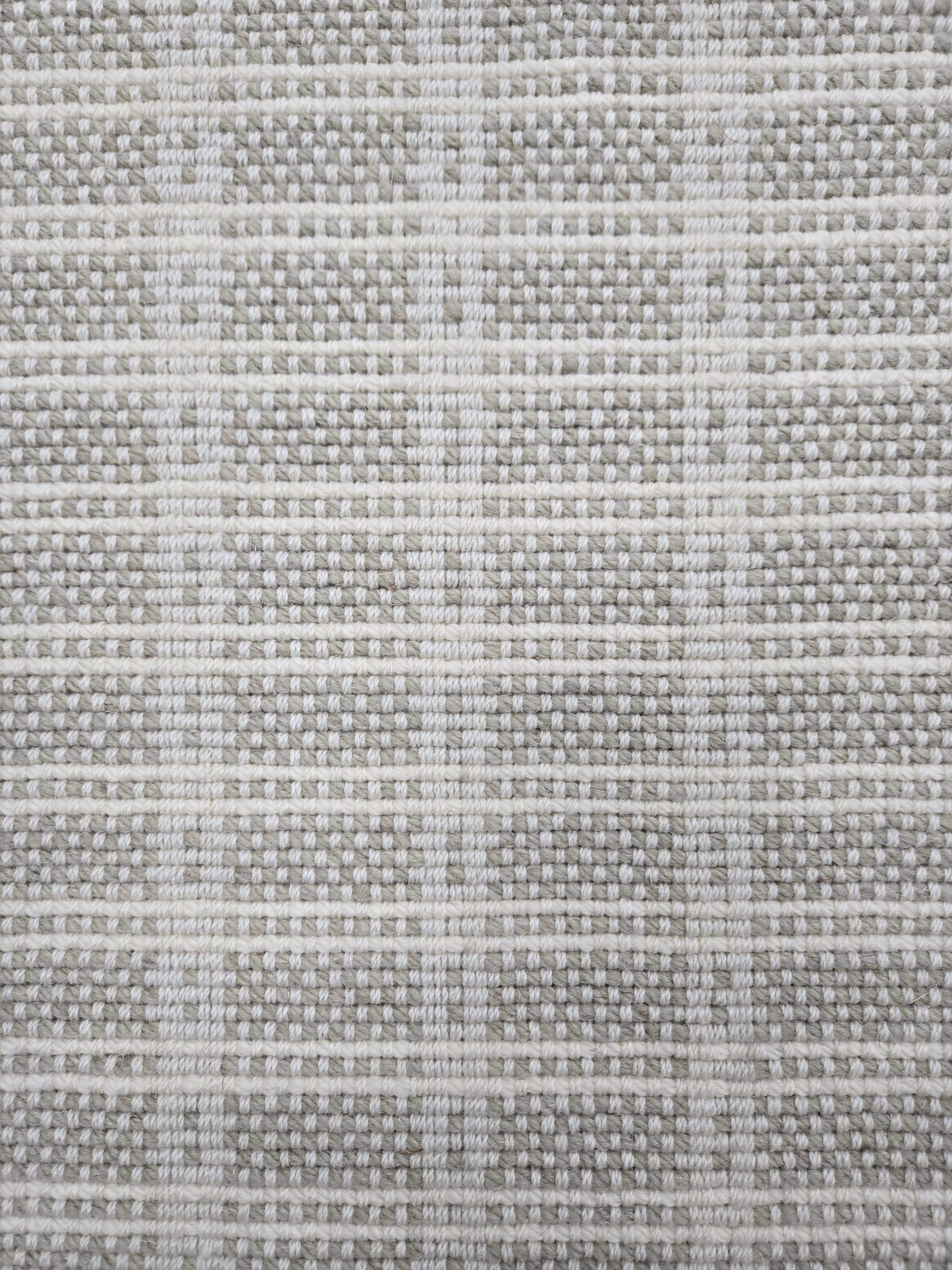 Broadloom carpet in slim plaid pattern in cream and ecru.