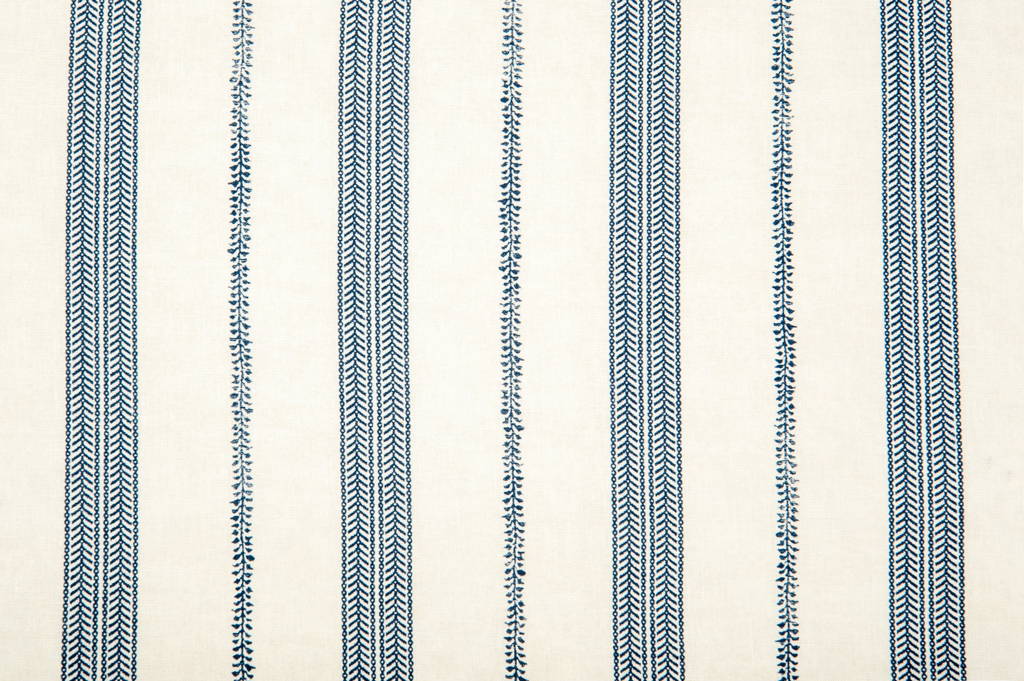 Detail of fabric in a small-scale botanical stripe print in navy on a cream field.