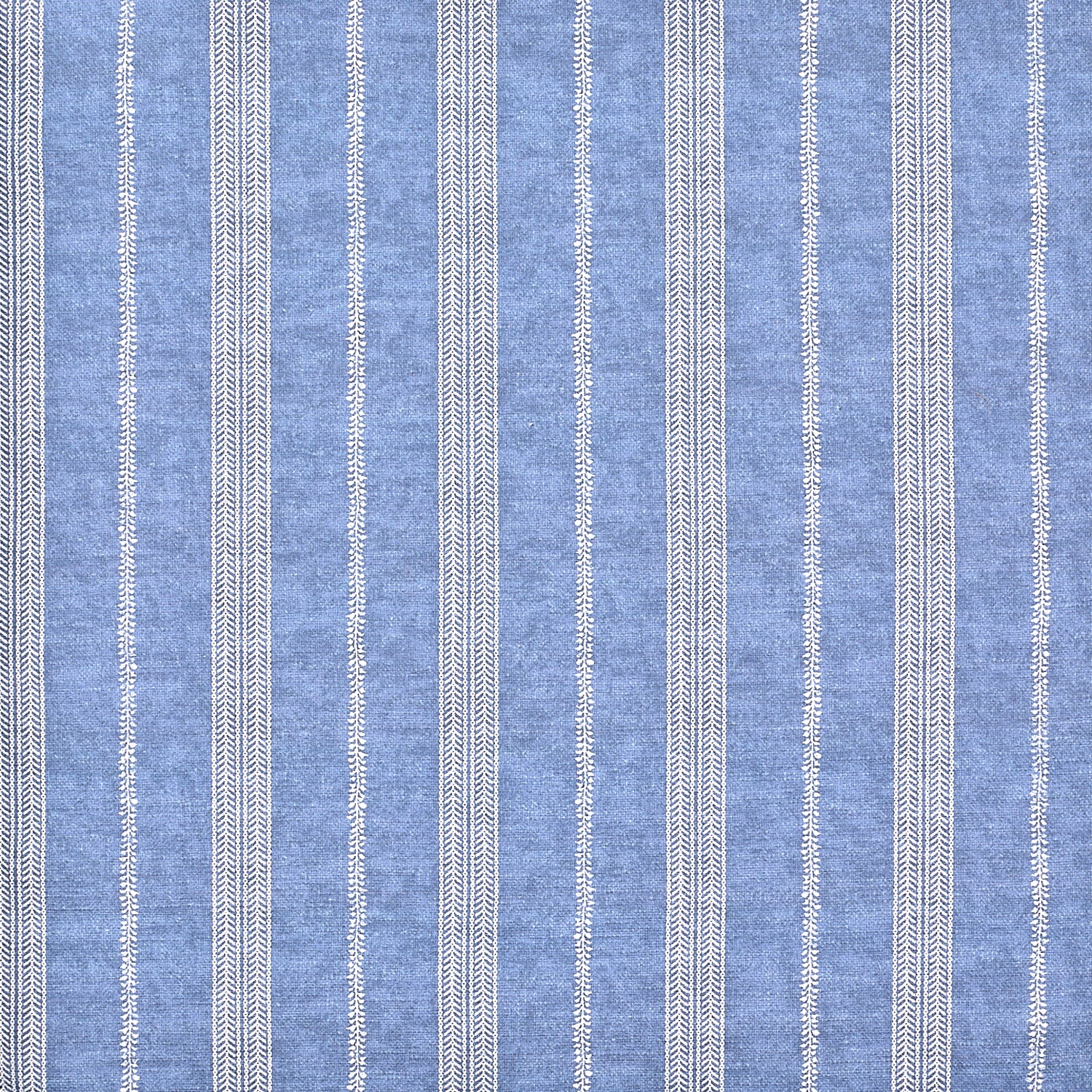 Detail of fabric in a small-scale botanical stripe print in cream on an indigo field.