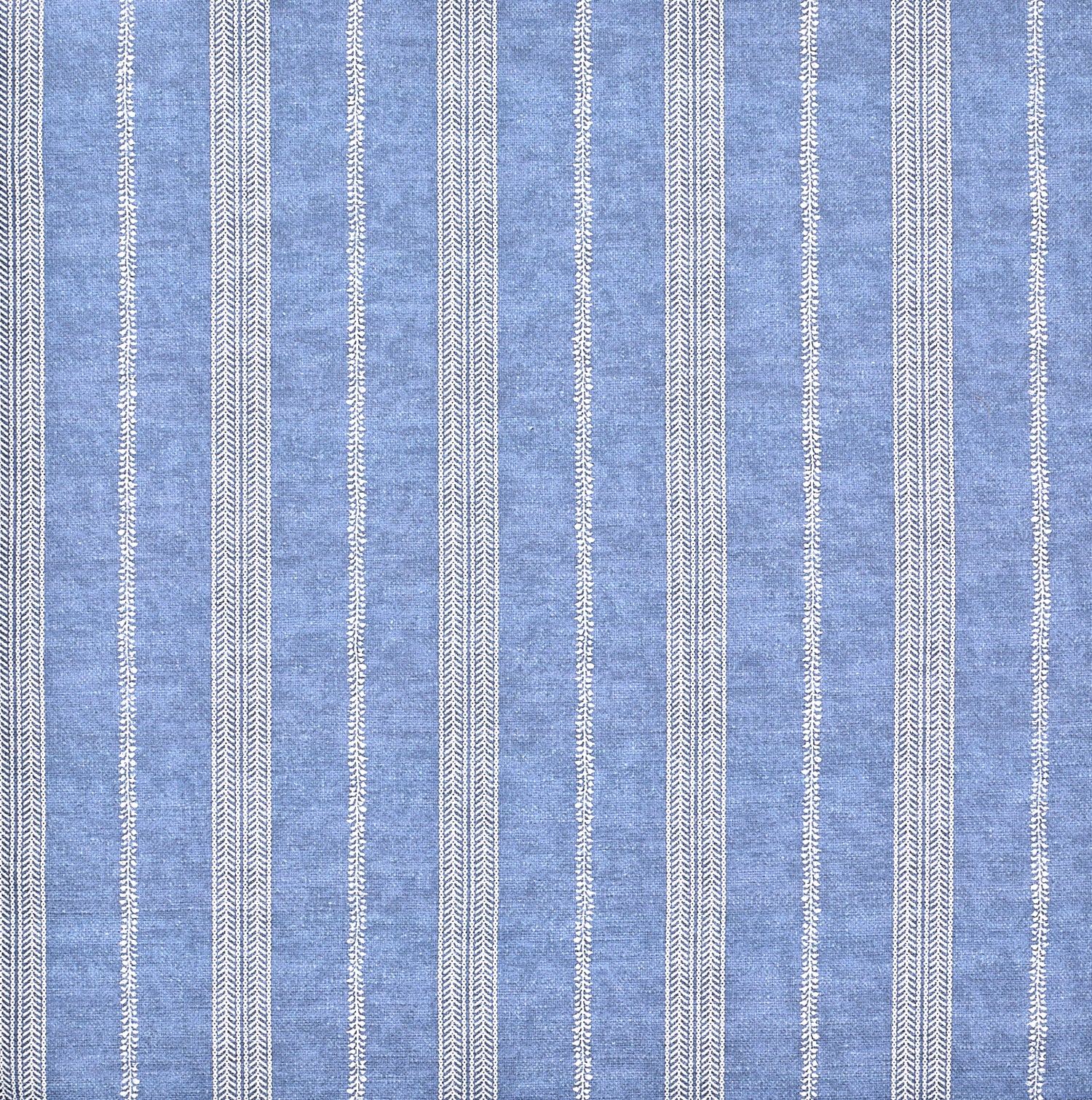 Detail of fabric in a small-scale botanical stripe print in cream on an indigo field.