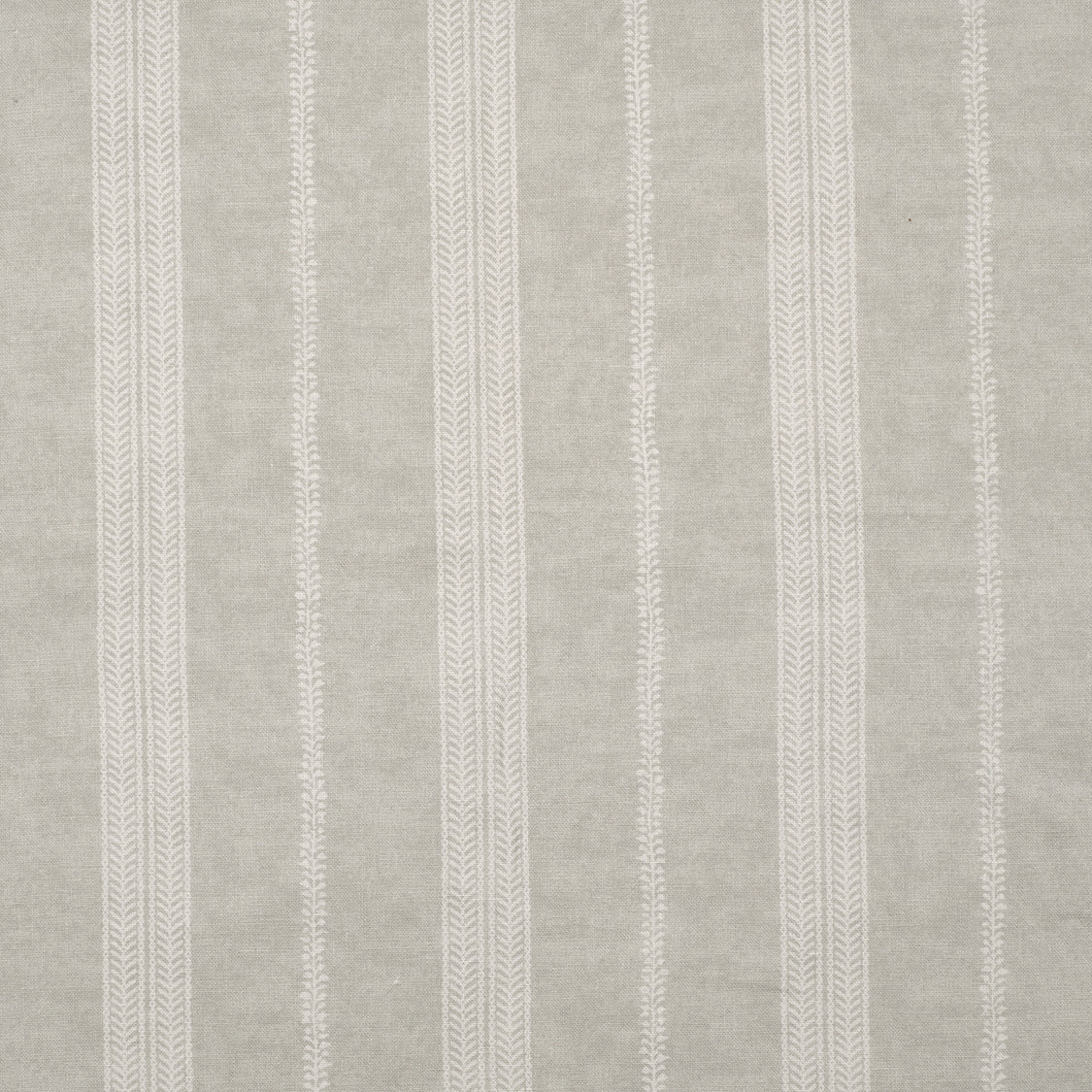Detail of fabric in a small-scale botanical stripe print in cream on a tan field.