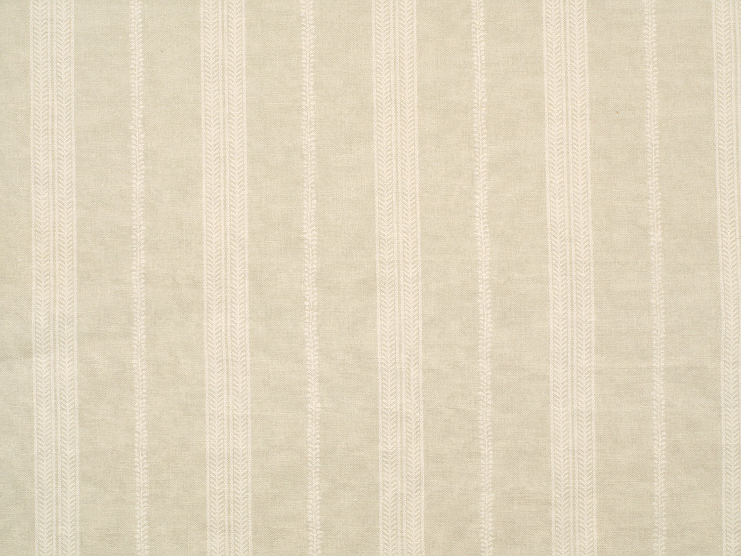 Detail of fabric in a small-scale botanical stripe print in cream on a tan field.