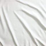 Close up of gently draped pin striped woven Indoor-Outdoor fabric in white.