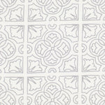 Detail of fabric in a damask lattice print in light gray on a white field.