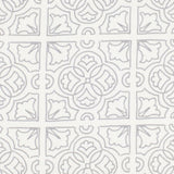 Detail of fabric in a damask lattice print in light gray on a white field.