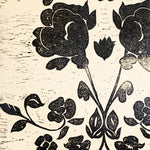Detail of wallpaper in a repeating floral damask pattern in black on a white field.