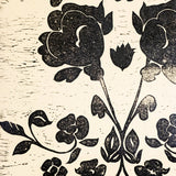 Detail of wallpaper in a repeating floral damask pattern in black on a white field.