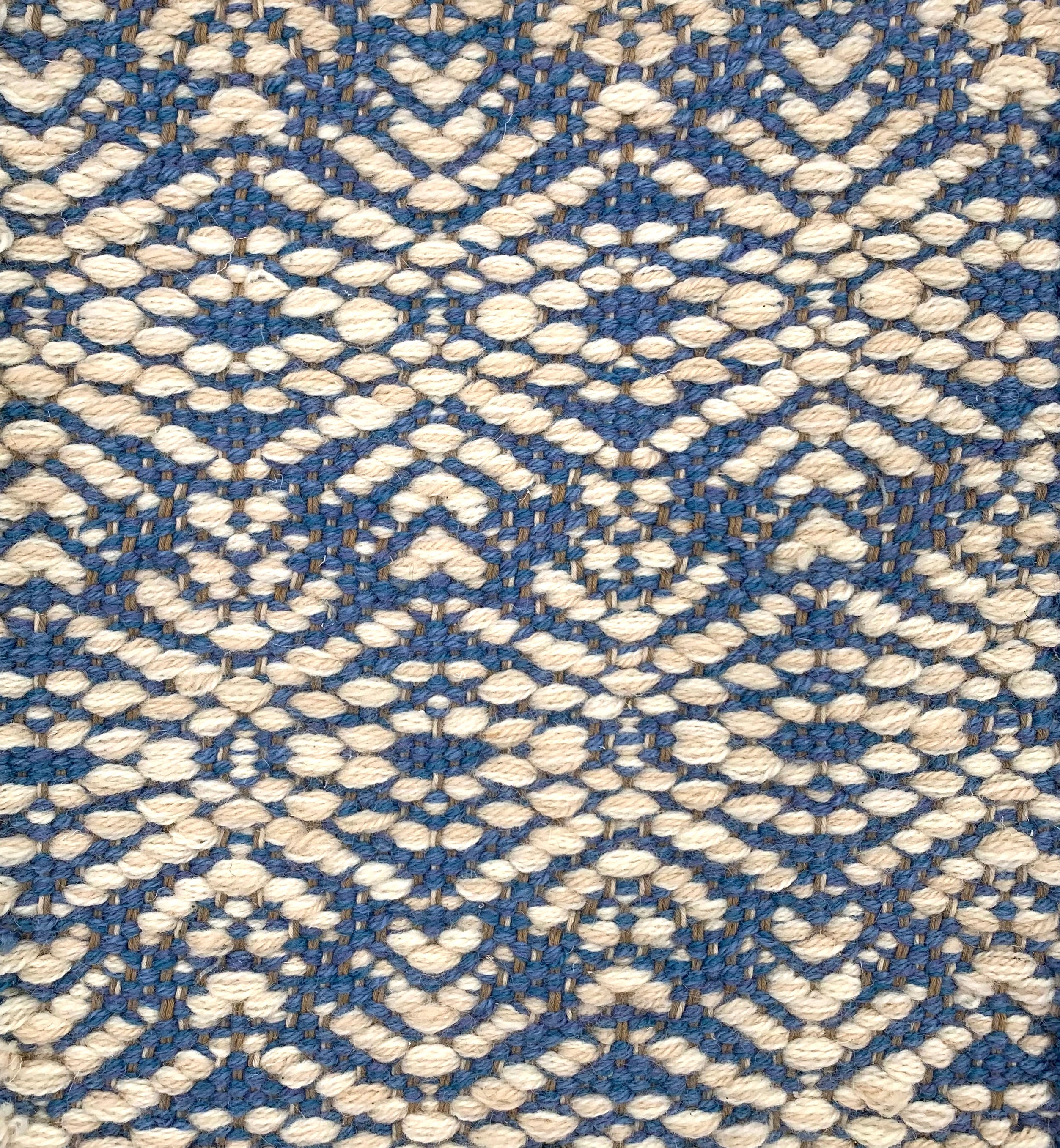 Handwoven rug detail in a contemporary design in blue and cream