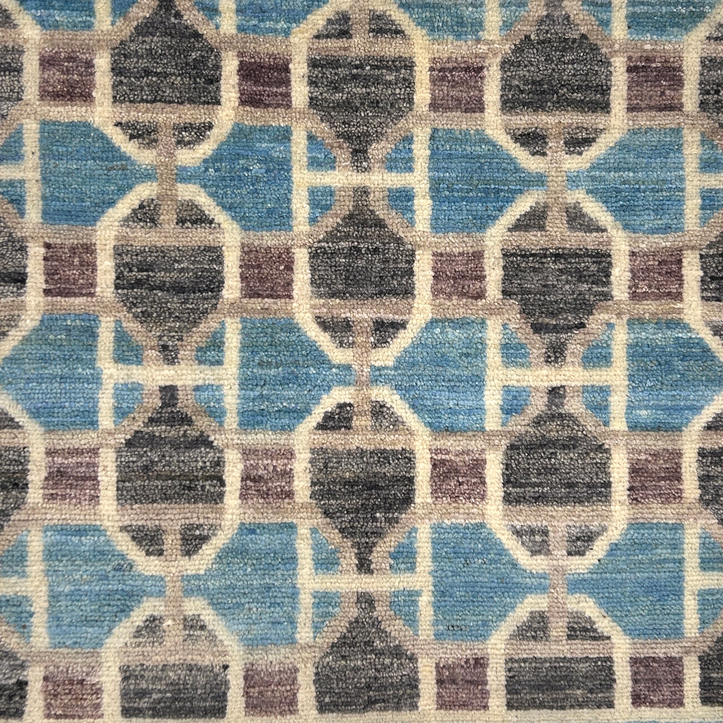 Patterned rug with geometric design in blue, brown, and beige colors.