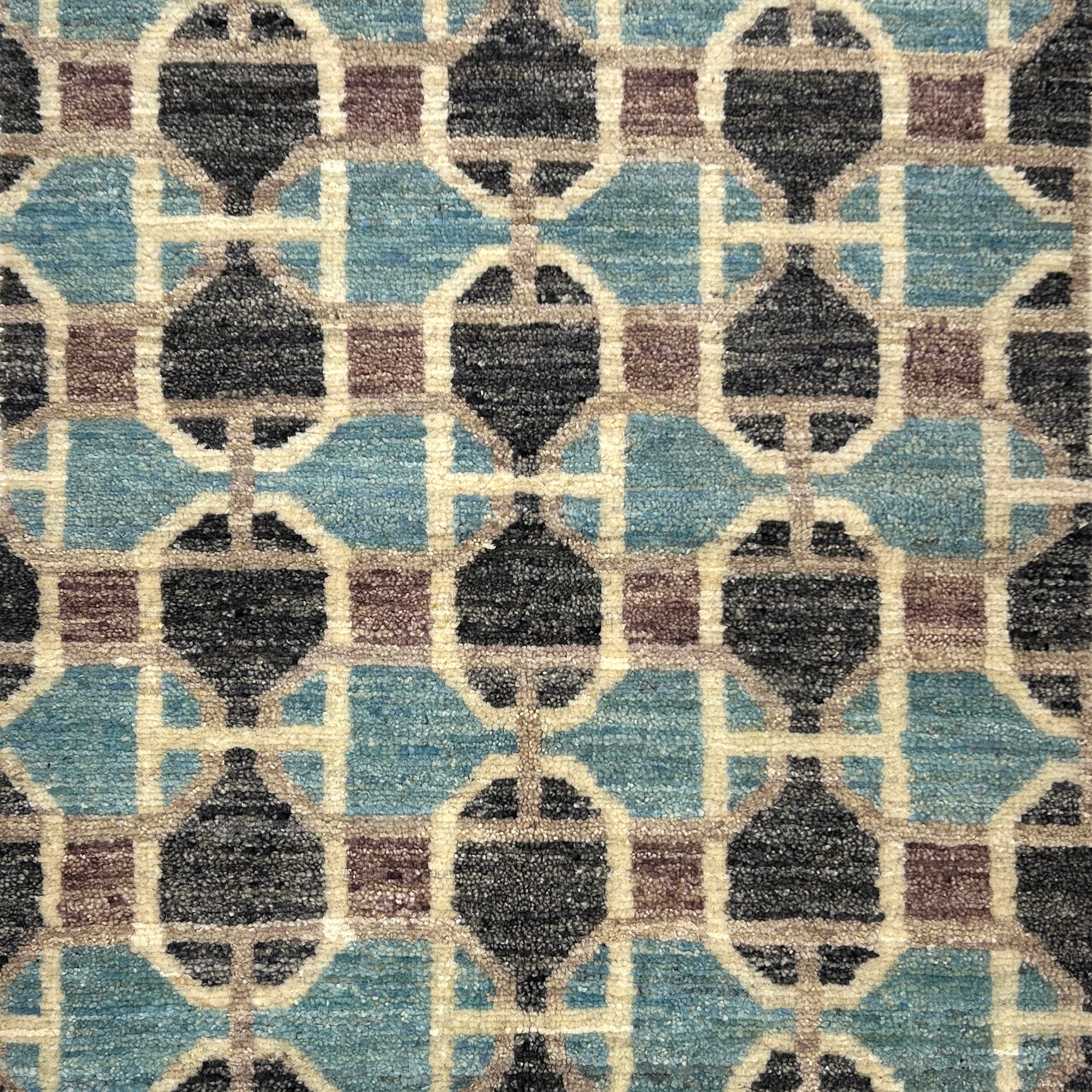 Patterned rug with geometric design in blue, brown, and beige colors.
