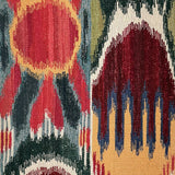 Close-up of a ikat patterned rug with geometric shapes in red, blue, and beige.