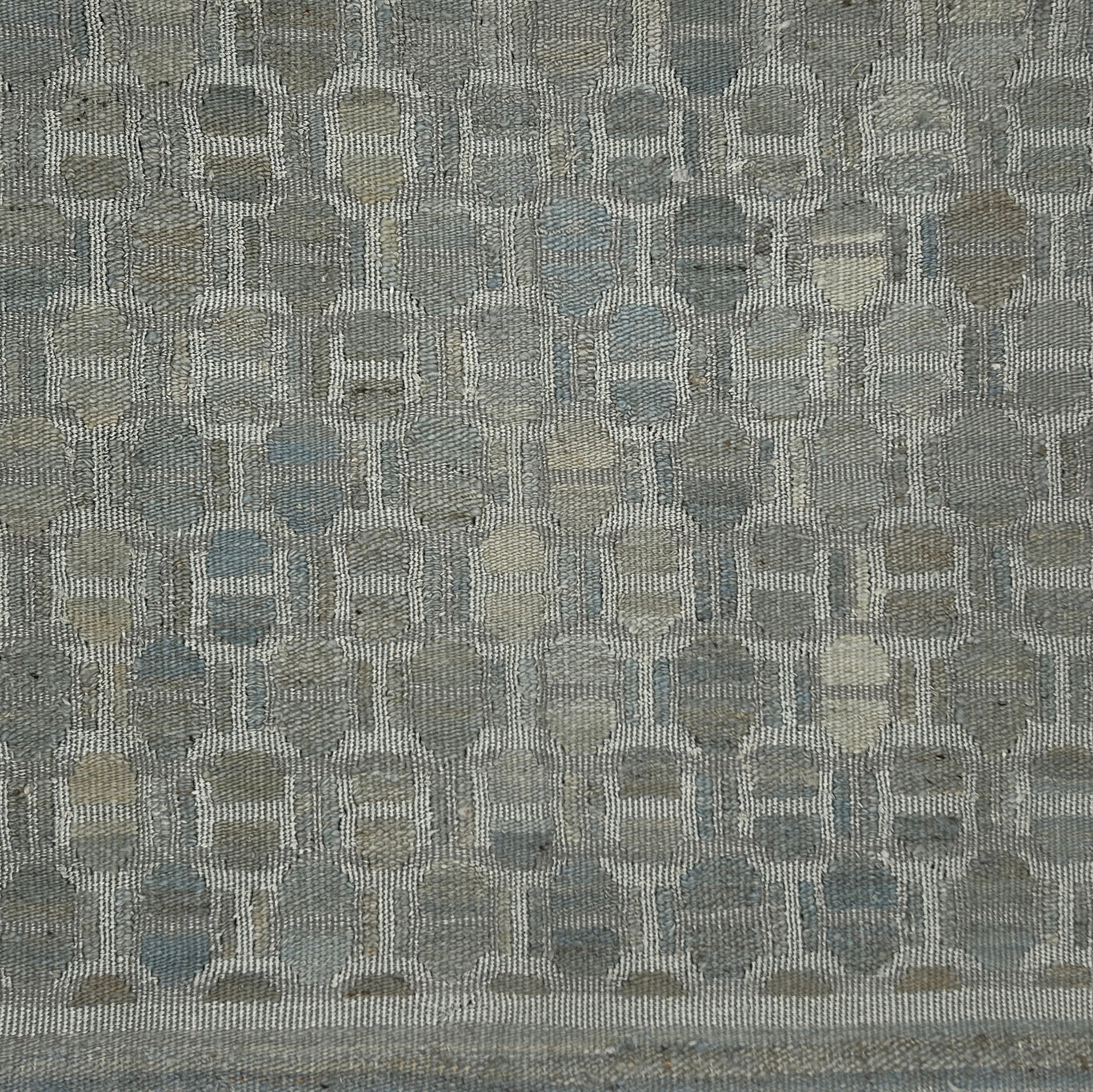 Textured fabric with a geometric pattern in shades of gray.