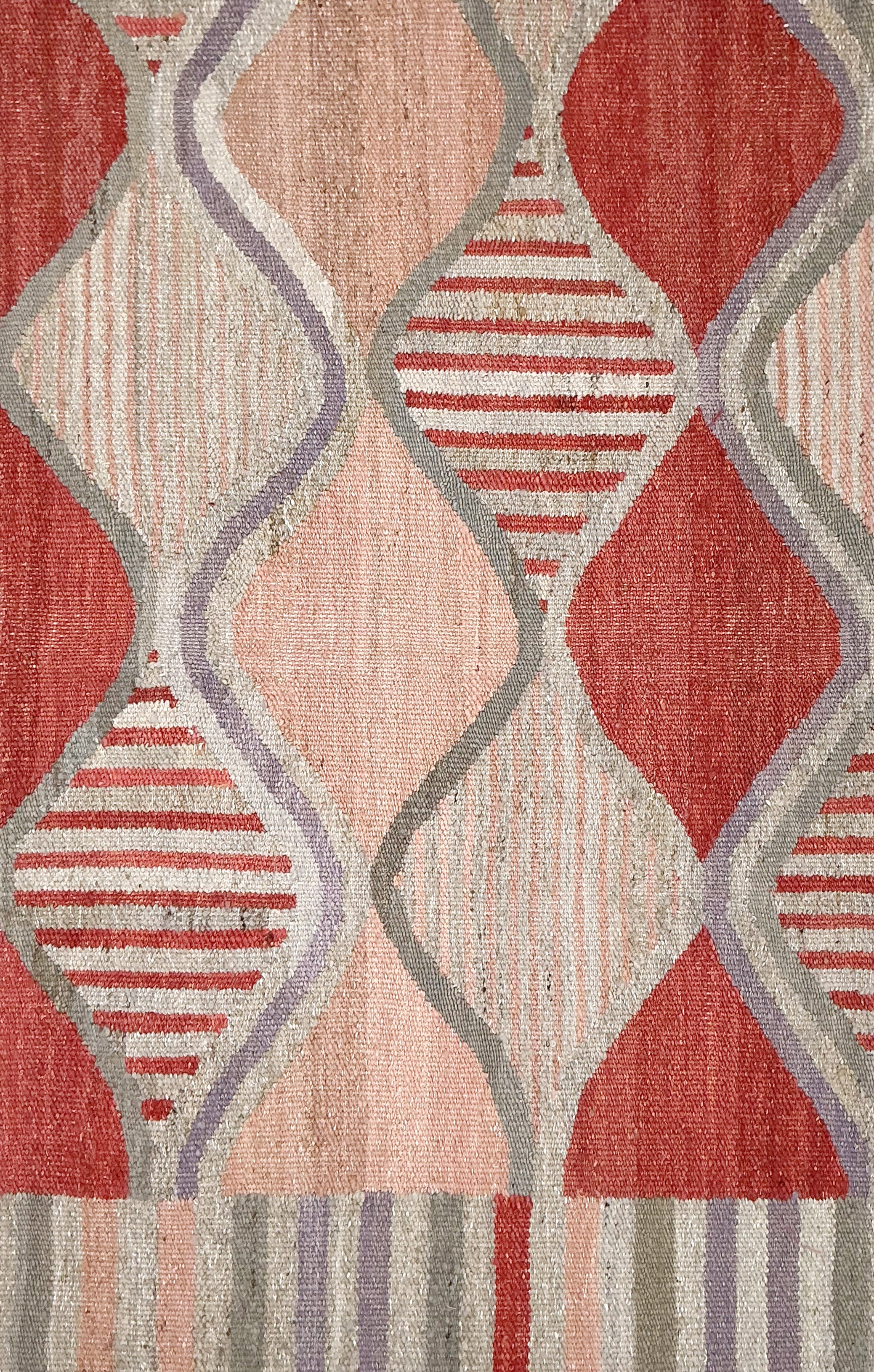 Patterned rug with red, beige, and gray geometric design