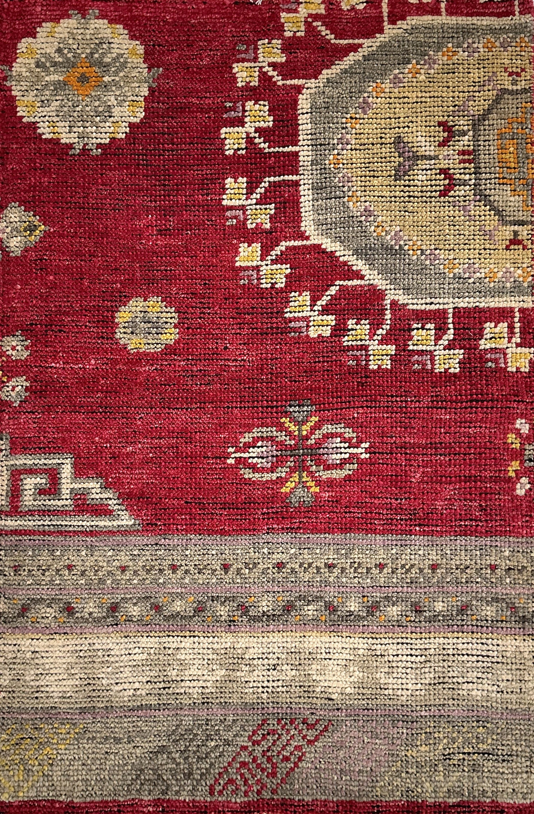 Decorative rug with geometric patterns on a red background