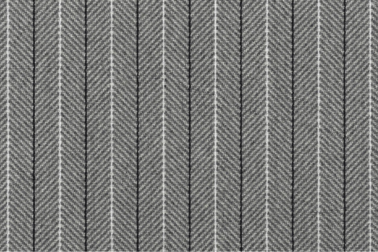 Broadloom carpet in a grey herringbone stripe with black and white pinstripes. 