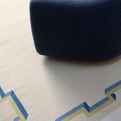 Navy blue chair on a patterned rug with geometric design