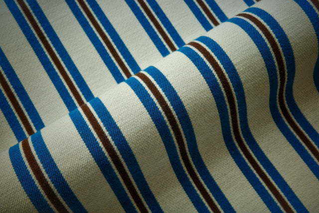 Close-up of fabric with blue and black stripes on a beige background