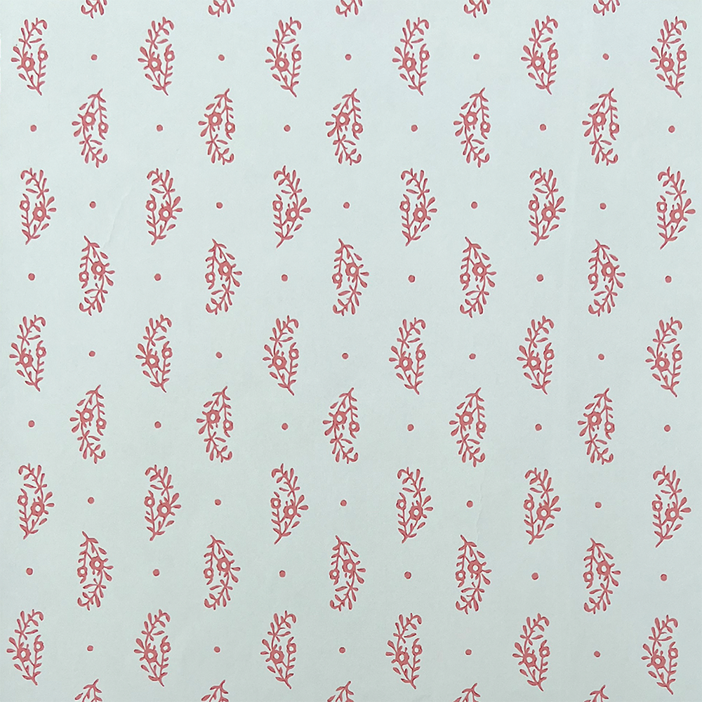 Detail of wallpaper in a floral paisley print in red on a light blue field.