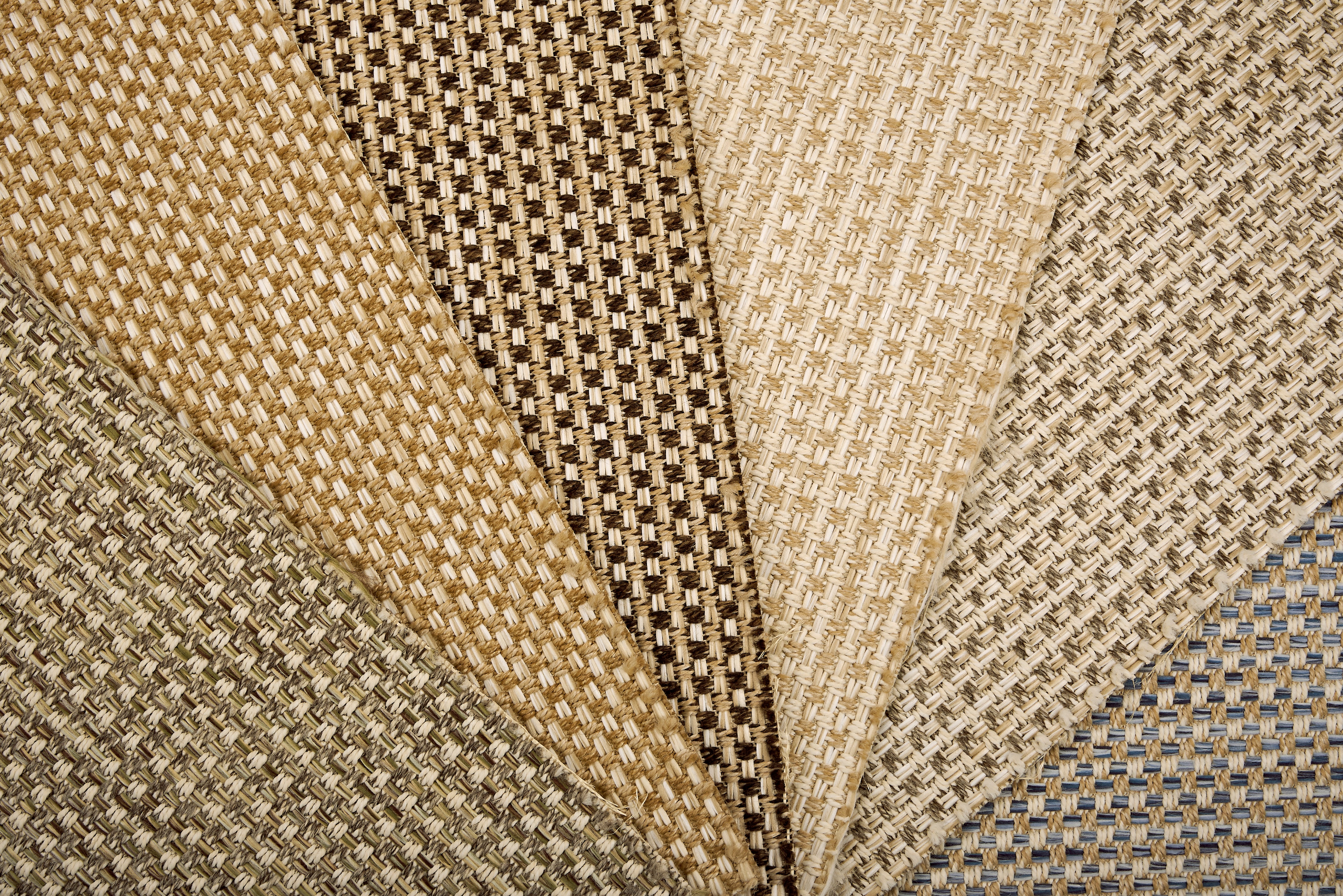 An array of broadloom carpet samples in textural neutral colors. 