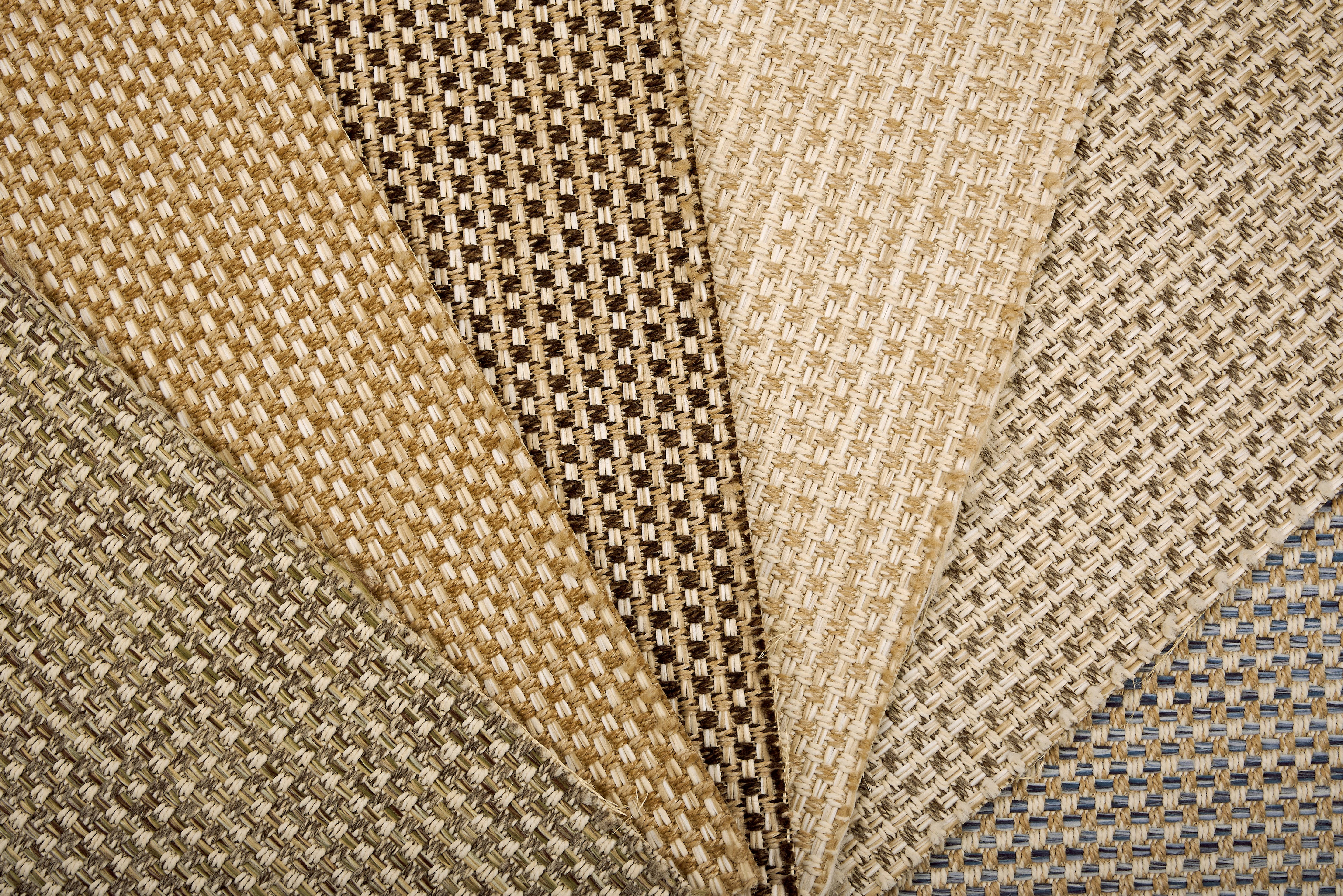 An array of broadloom carpet samples in textural neutral colors. 