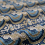 Close-up of patterned fabric with blue, beige, and brown colors.