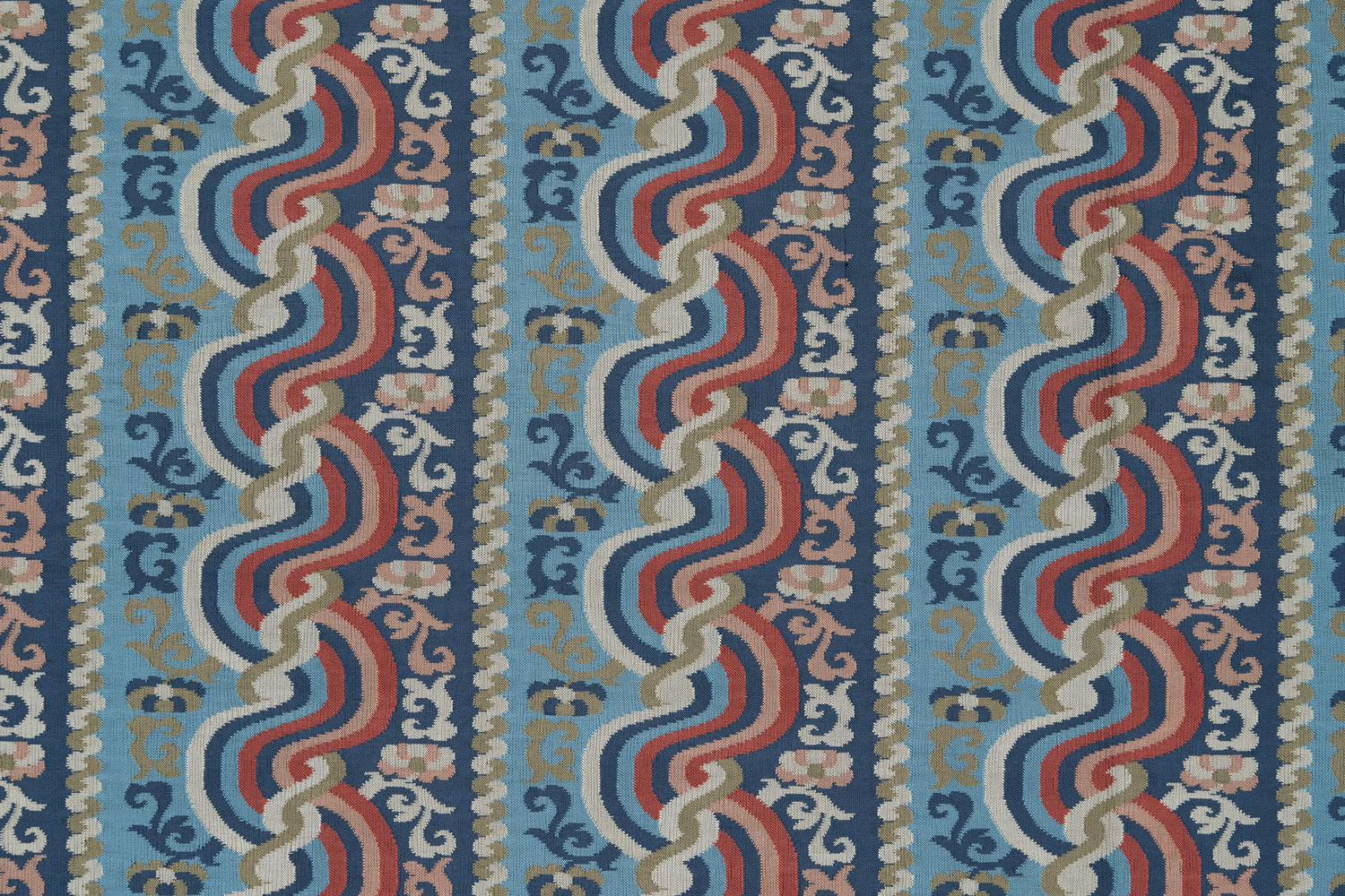 Handwoven silk fabric with scrolling stripe design in shades of blue, red, pink, tan and white. 
