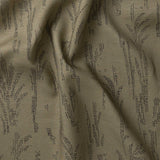 Detail of gently draped printed fabric with a black pointillist wheat frond pattern on a sage green background. 