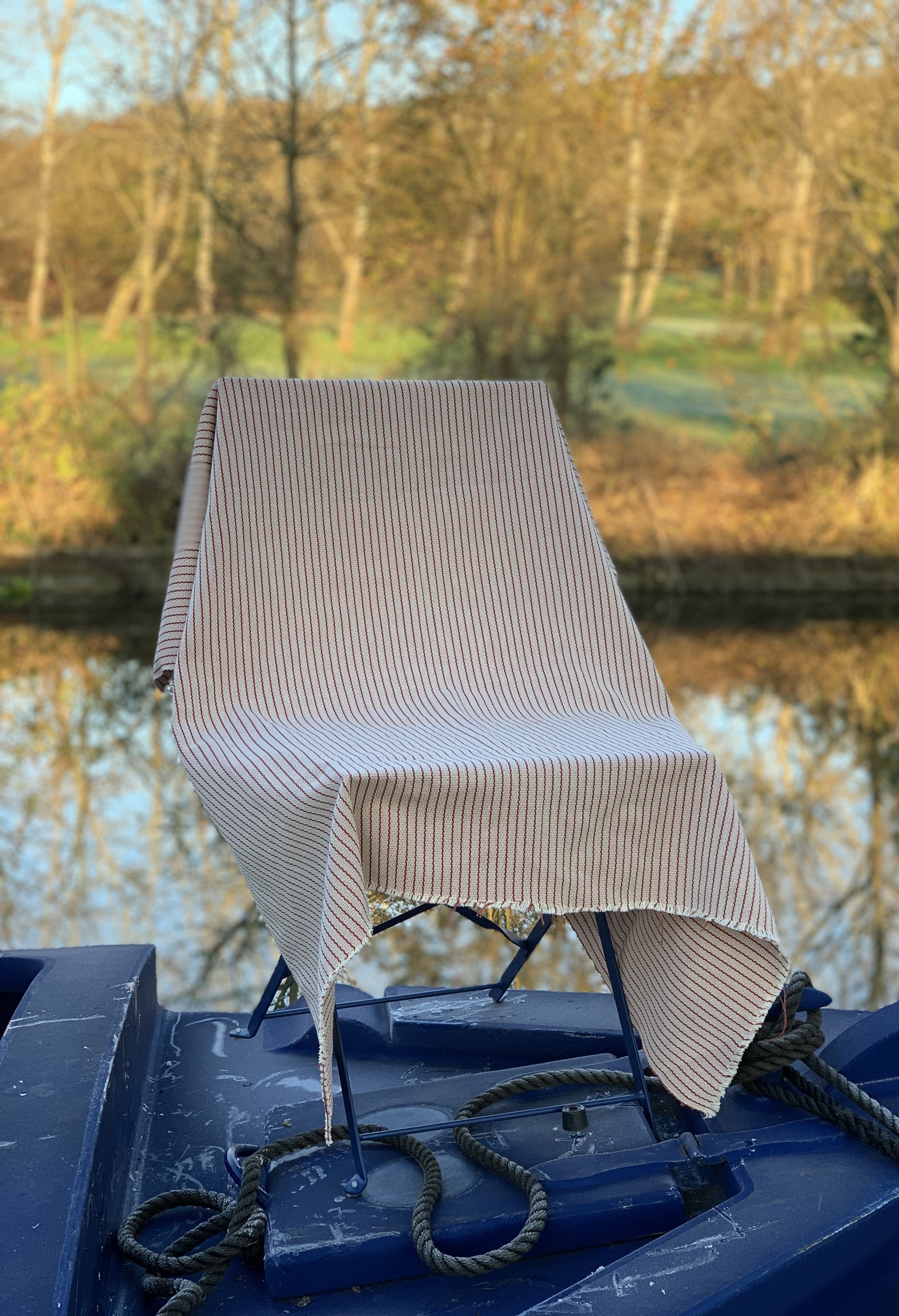 Red and white striped  fabric draped over a chair with a natural background