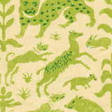 Detail of wallpaper in a playful animal and botanical print in green and blue on a cream field.