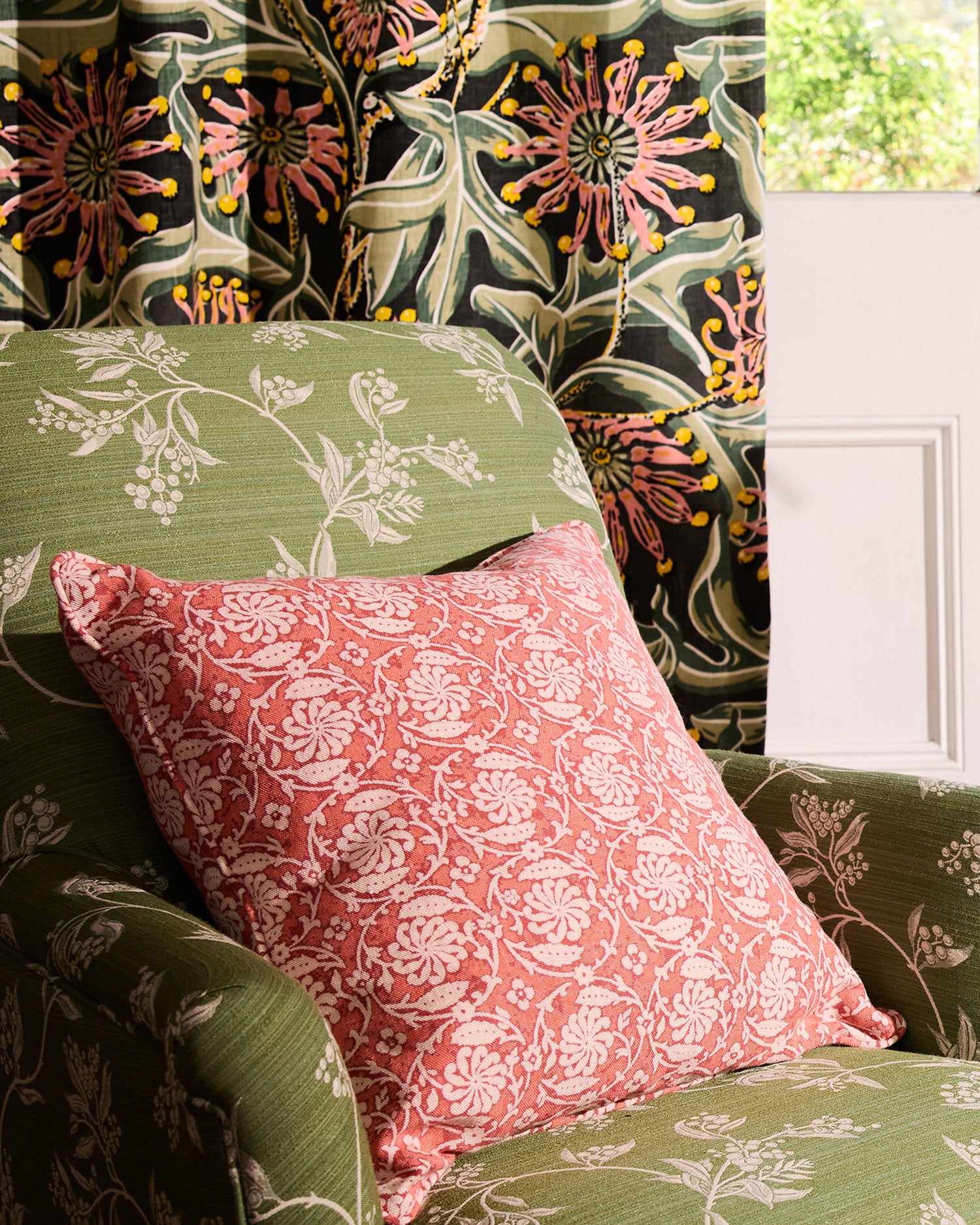 Floral-patterned cushions on a chair with a door in the background
