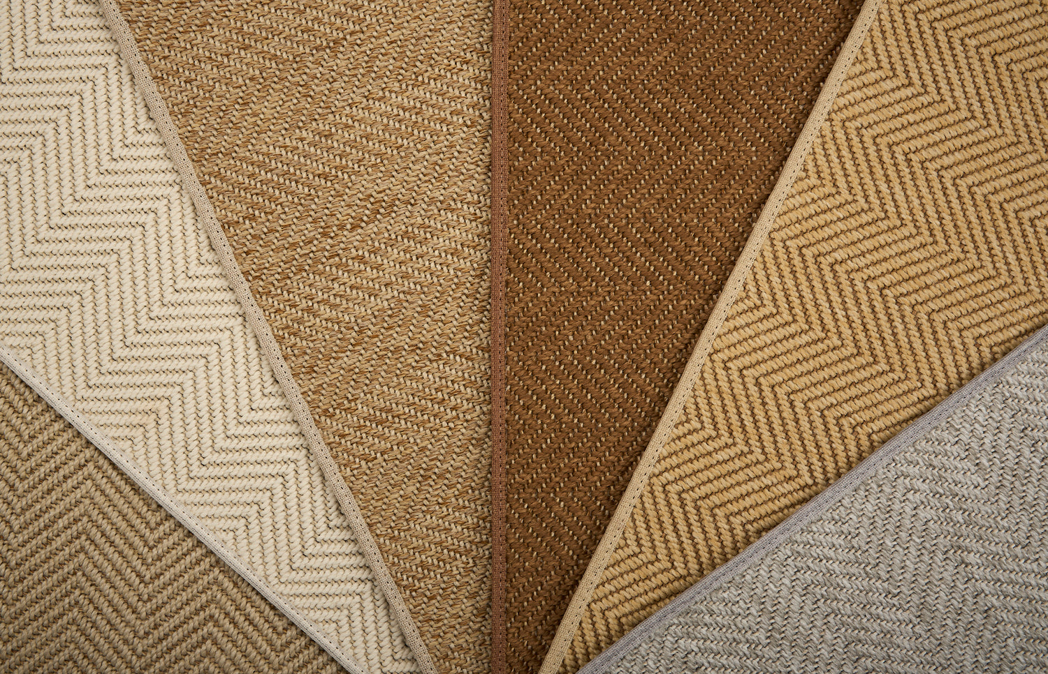 Collection of woven rugs in beige, brown, and gray.