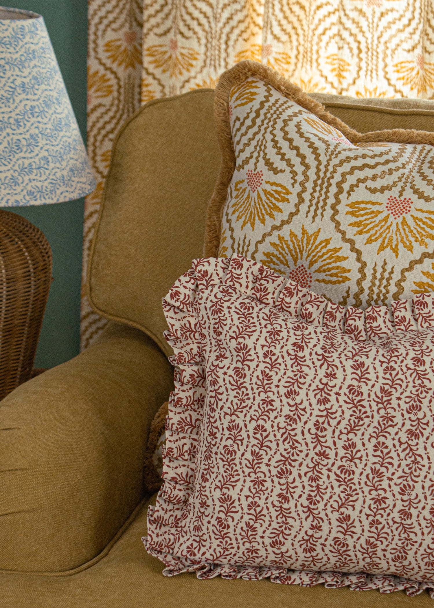 Tan side chair with floral printed accent pillows in red and ochre yellow. 