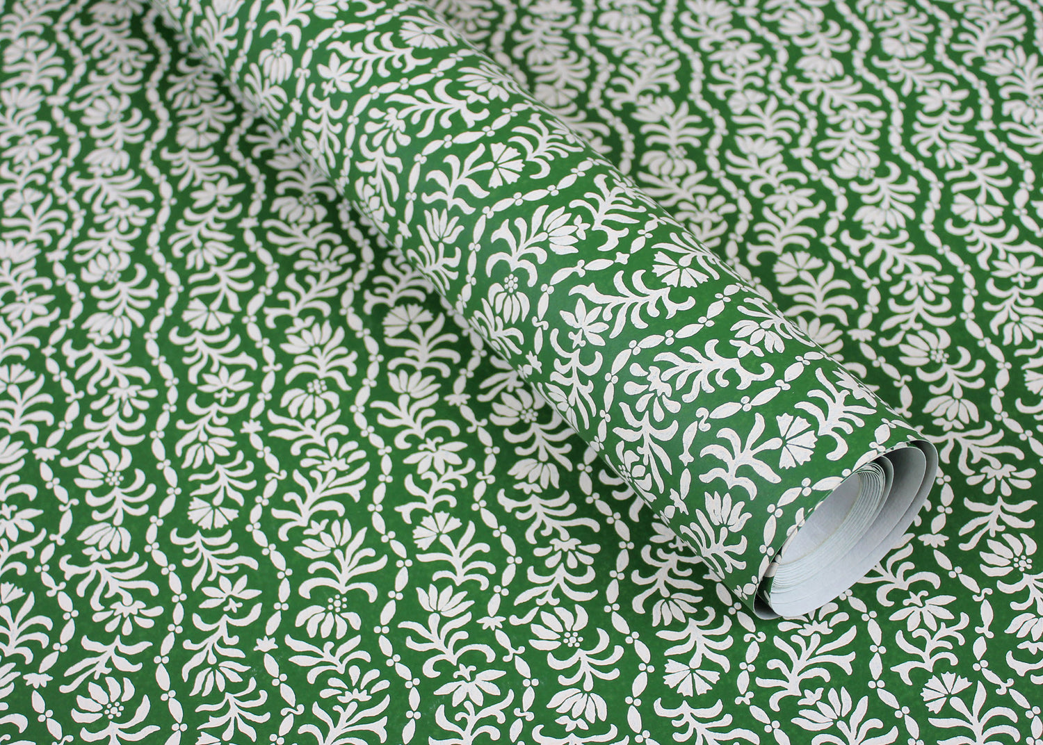 Wallpaper in a wavy floral stripe design in white on green