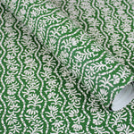 Wallpaper in a wavy floral stripe design in white on green