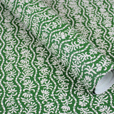 Wallpaper in a wavy floral stripe design in white on green