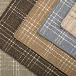 Stack of windowpane plaid broadloom carpets in various colors. 