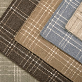 Stack of windowpane plaid broadloom carpets in various colors. 