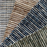 Textural broadloom carpet in grey, brown, navy blue and green.