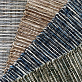 Textural broadloom carpet in grey, brown, navy blue and green.