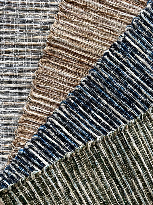 Textural broadloom carpet in grey, brown, navy blue and green.