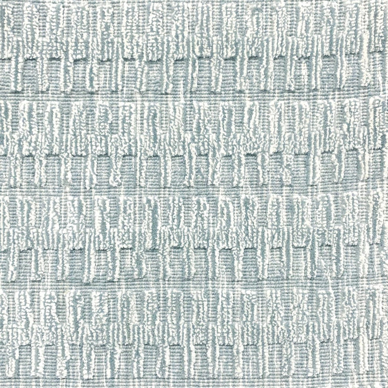 A close-up of a broadloom rug in a vertical ribbed pattern  in a neutral mix of off-white, and aqua blue.