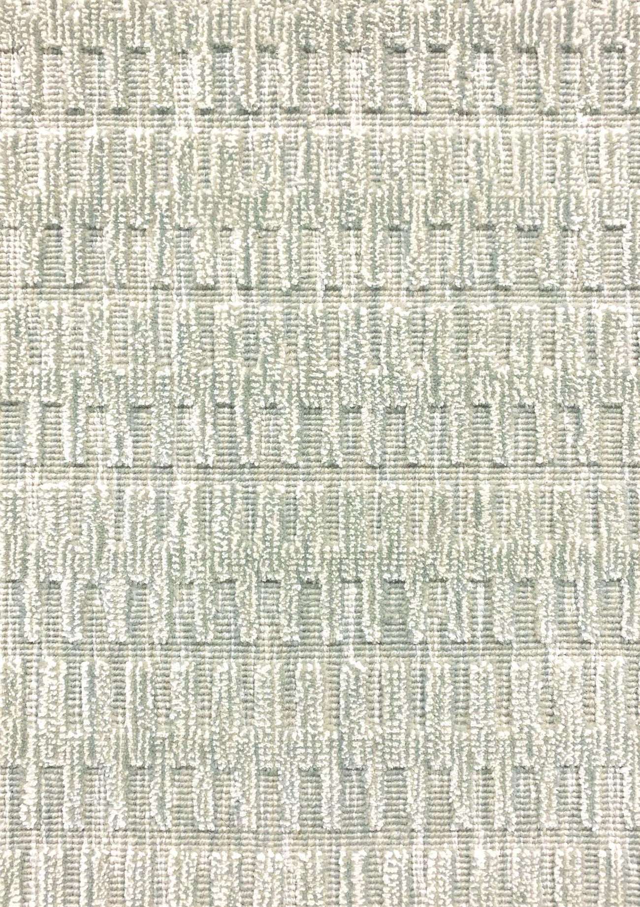 A close-up of a broadloom rug in a vertical ribbed pattern  in a neutral mix of off-white, and sage green. 